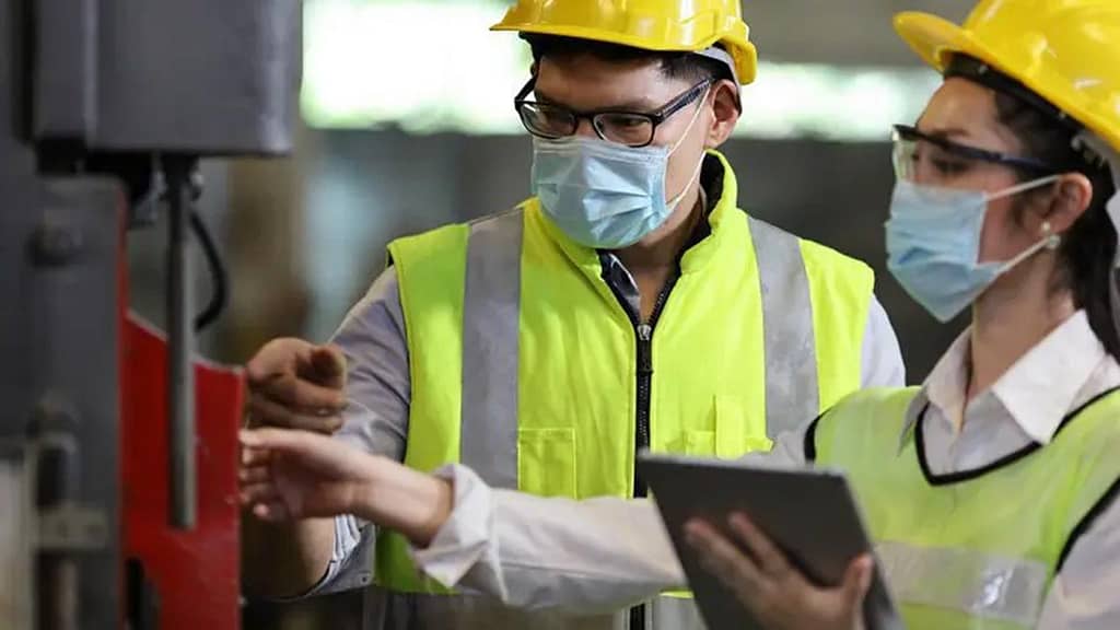 field service technicians with ipad wearing face masks ppe inspecting service equipment
