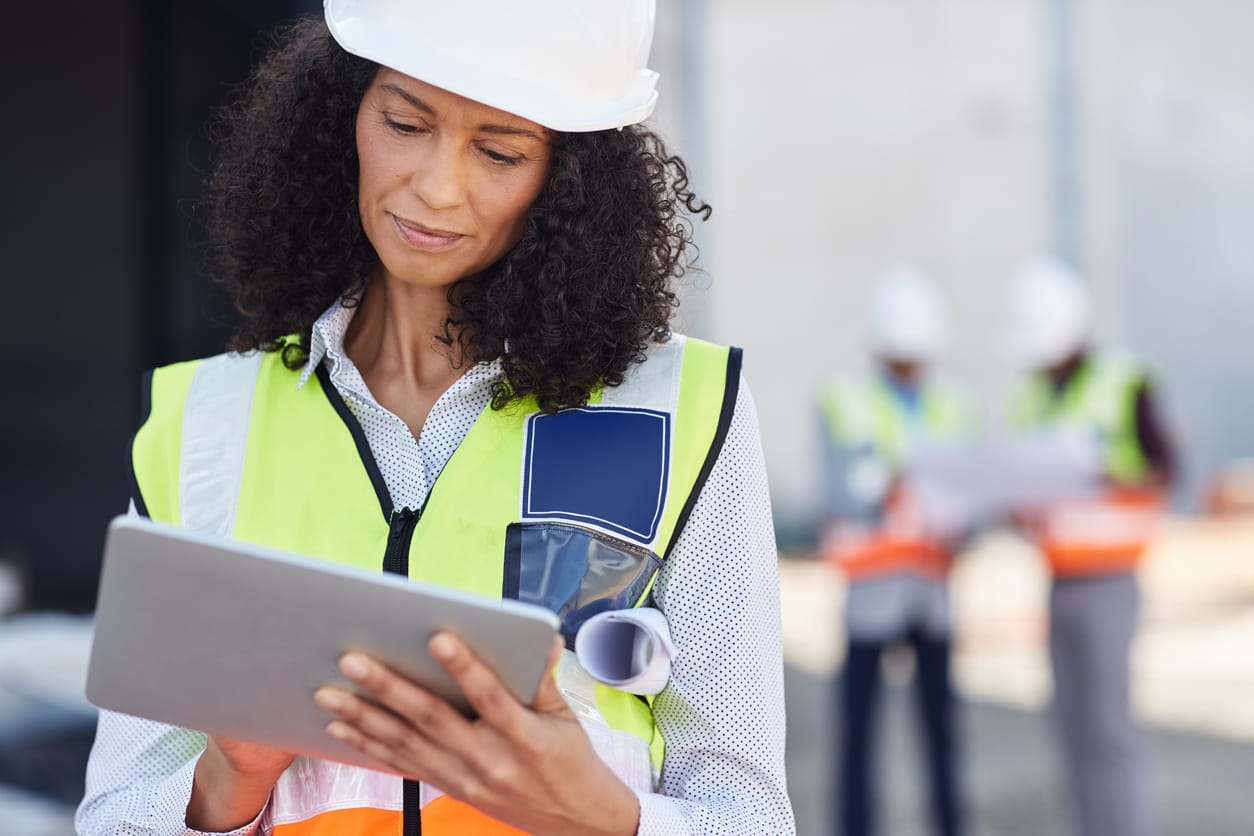 Using job management software - Female field service manager using a tablet device to manage her projects and teams.